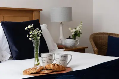 a table with two cups and some pastries on it at Kerensa in Portreath