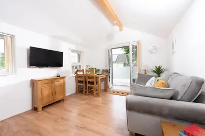 a living room with a couch and a flat screen tv at Kerensa in Portreath