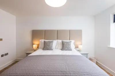 a bedroom with a large white bed with two lamps at Waves Falmouth-hot tub games room very close to Swanpool beach and Falmouth GC in Falmouth