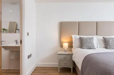 a bedroom with a bed with a lamp and a sink at Waves Falmouth-hot tub games room very close to Swanpool beach and Falmouth GC in Falmouth
