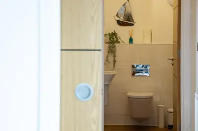 a bathroom with a toilet and a sink at Waves Falmouth-hot tub games room very close to Swanpool beach and Falmouth GC in Falmouth