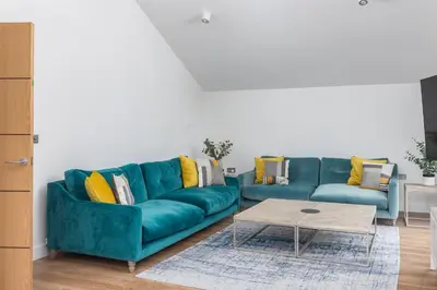 a living room with a blue couch and a coffee table at Waves Falmouth-hot tub games room very close to Swanpool beach and Falmouth GC in Falmouth