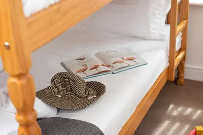 a bed with two books and a hat on it at Rosebud in Portreath