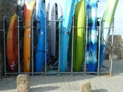 a bunch of surfboards lined up in a rack at The Grey Mullet Guest House in St Ives