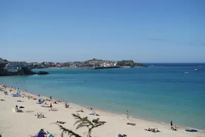 a group of people on a beach near the water at The Grey Mullet Guest House in St Ives