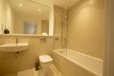 a bathroom with a toilet and a sink and a shower at Luxury beach apartment in Perranporth
