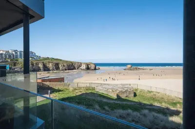 a view of the beach from the balcony of a house at Luxury beach apartment in Perranporth