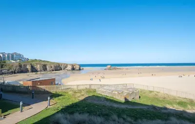 a view of a beach with people on it at Luxury beach apartment in Perranporth