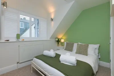 a bedroom with a white bed with a window at Happy Days in St Ives