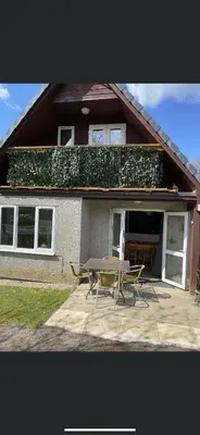 a house with a table and chairs in front of it at 128 Hengar Manor in Bodmin