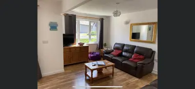 a living room with a leather couch and a television at 128 Hengar Manor in Bodmin