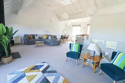 a living room with a blue couch and chairs at Peaceful, rural cottage on the outskirts of Padstow in Padstow