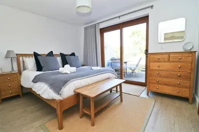 a bedroom with a bed with blue pillows at Peaceful, rural cottage on the outskirts of Padstow in Padstow