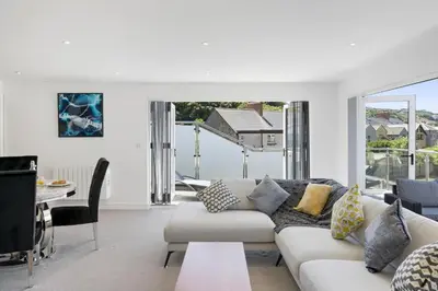 a living room with a white couch and a table at The Cube in Portreath