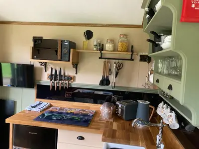 a kitchen with a wooden counter top with a microwave at Brook the Shepherd Hut in Saltash