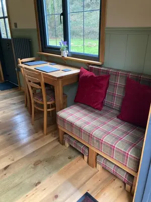 a living room with a couch and a table at Brook the Shepherd Hut in Saltash