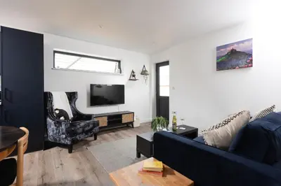 a living room with a blue couch and a tv at Bay Dream - Free parking, close to beach, pet friendly in Carbis Bay