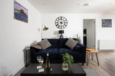 a living room with a blue couch and a table at Bay Dream - Free parking, close to beach, pet friendly in Carbis Bay