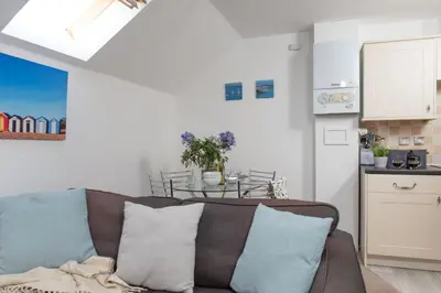a living room with a couch and a table at 7 Trevose House, St Ives in Carbis Bay