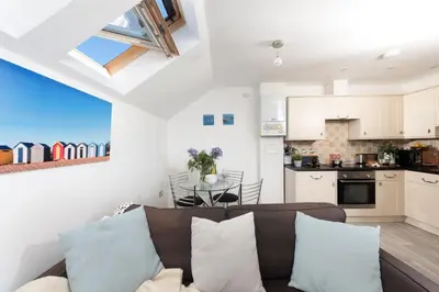 a living room with a couch and a kitchen at 7 Trevose House, St Ives in Carbis Bay