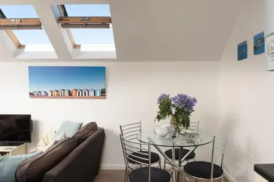 a living room with a table and a couch at 7 Trevose House, St Ives in Carbis Bay