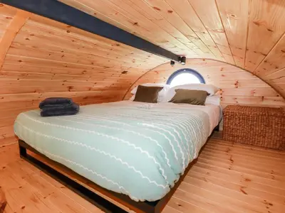 a bed in a log cabin with a window at The Olju in Truro