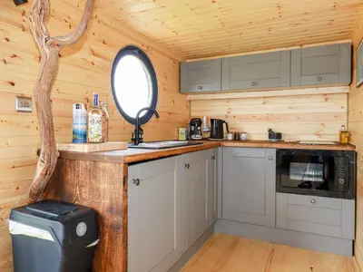 a kitchen in a log cabin with a window at The Olju in Truro