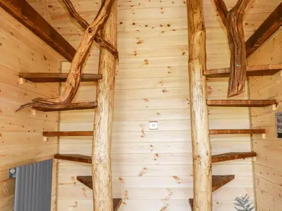 a room with logs on the wall of a log cabin at The Olju in Truro