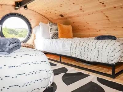 a bedroom with a bed and a window in a cabin at The Olju in Truro
