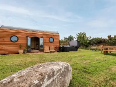 a small cabin with a rock in a yard at The Olju in Truro