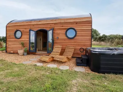 a tiny house with a couple of chairs in the yard at The Olju in Truro