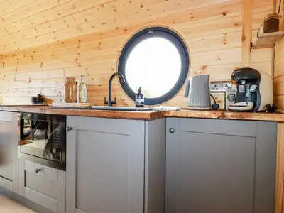 a kitchen with a sink and a round window at Stargaze in Truro
