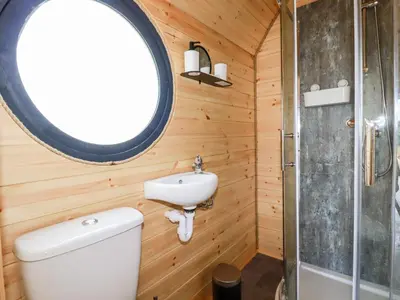 a bathroom with a toilet and a sink and a window at Stargaze in Truro