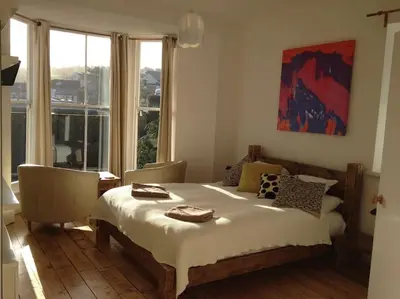 a bedroom with a bed and a large window at organic panda in St Ives