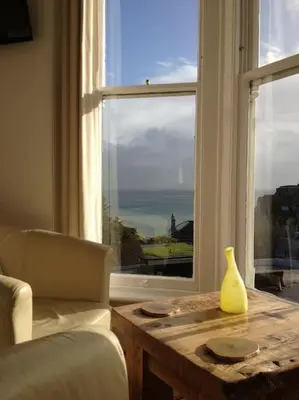 a table with a vase on it next to a window at organic panda in St Ives