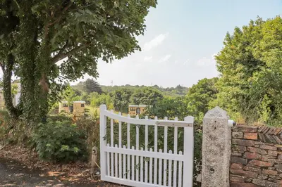 a white gate in front of a stone wall at Sunflower in Redruth