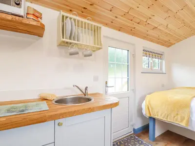 a kitchen with a sink and a bed in a room at Sunflower in Redruth