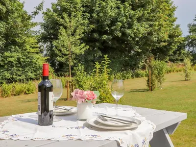 a table with a bottle of wine and two glasses at Rose in Redruth