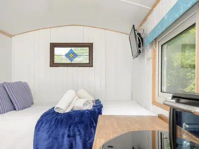 a small room with a bed and a window at Shepherds Hut in Lostwithiel