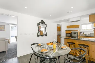 a kitchen and dining room with a glass table and chairs at Rosevilla Farmhouse in Portreath