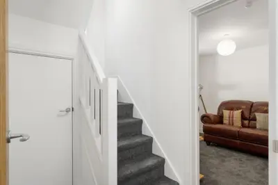 a stairway leading up to a living room with a couch at Rosevilla Farmhouse in Portreath