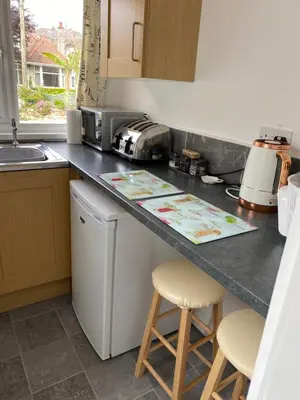 a kitchen with a counter with two stools at 24trenance in Newquay