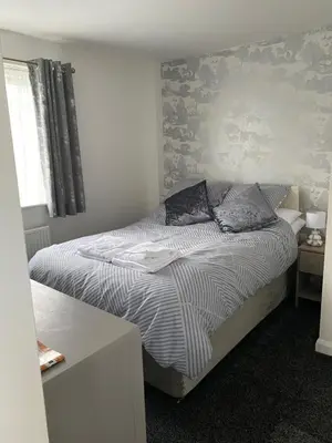 a bedroom with a bed with a striped comforter at 24trenance in Newquay