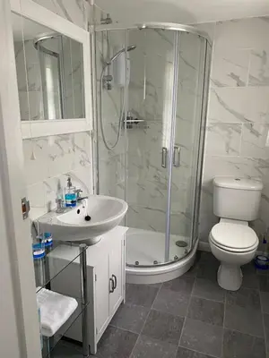 a bathroom with a shower and a toilet and a sink at 24trenance in Newquay