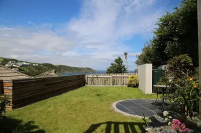 a backyard with a fence and a grass yard at Maen Lay, Gorran Haven in Gorran Haven
