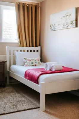 a white bed in a bedroom with a window at Maen Lay, Gorran Haven in Gorran Haven
