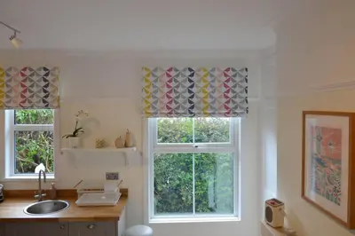 a kitchen with two windows and a sink at Oakroyd in Gorran Haven