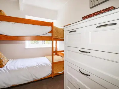a bedroom with two bunk beds and a closet at Gwynn Cottage in Bodmin