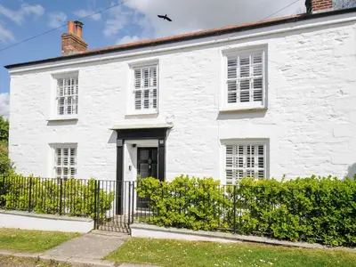 a white house with a fence in front of it at Quay House in St Austell