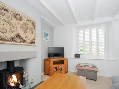 a living room with a fireplace and a tv at Quay House in St Austell